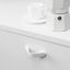 DROPP aluminium handle with geometric folded profile and ergonomic design, mounted on a contemporary cabinet drawer.