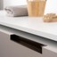 HEXXA Aluminium-Profilgriff mit abgeschrägtem integriertem Design an einer modernen Küchenschranktür montiert.