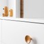 DISC runder Holzknopf mit glatter, minimalistischer Form an einer modernen Möbelschublade montiert.