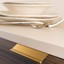 WING Aluminium-Profilgriff mit eleganter flügelförmiger Gestaltung an einer modernen Schranktür montiert.