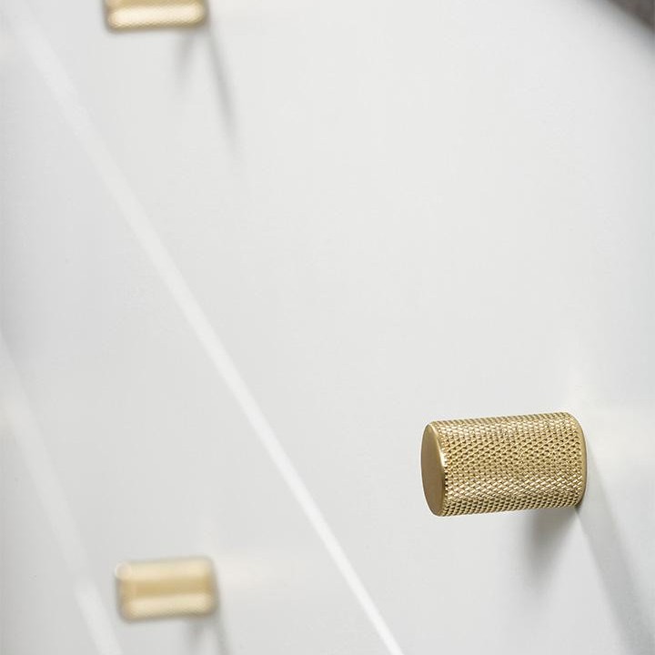 GRAF zylindrischer Aluminiumknopf mit strukturierter Netzoberfläche im Industrial-Design an einer modernen Möbelfront.