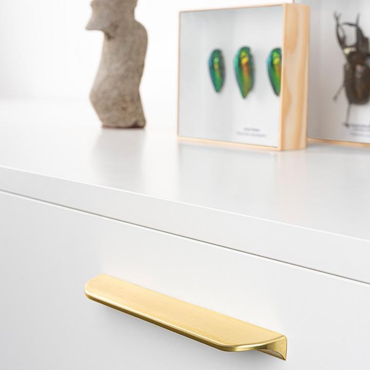 NICK Zamakgriff und passender Knopf mit sanftem modernem Design an einer modernen Schubladenfront montiert.