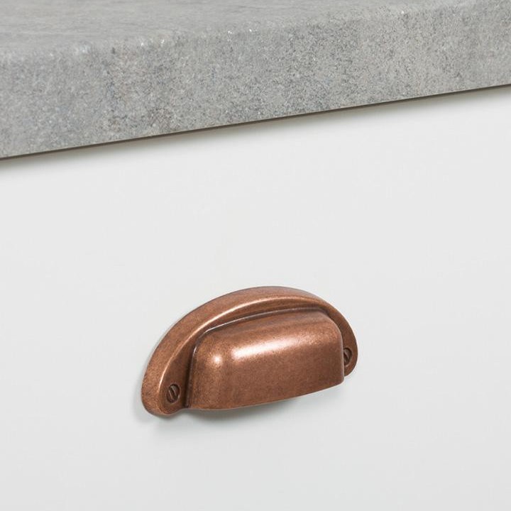 PETRA Muschelgriff aus Zamak mit klassischem Vintage-Design an einer gerahmten Schubladenfront montiert.