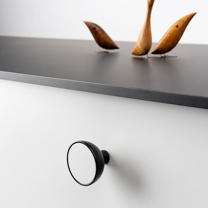 BOL runder Holz- und Aluminiumknopf mit schalenförmigem Design an einer modernen Möbeltür montiert.