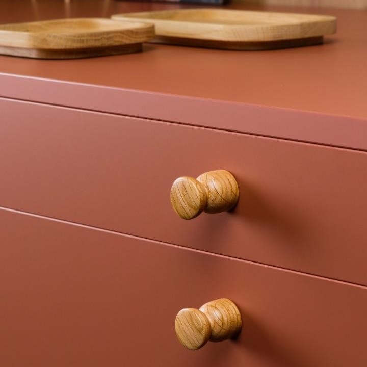 PIECE Massivholzknopf in Form eines Schachbauern an einer modernen Möbelfront montiert.