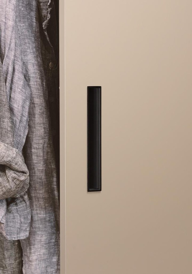 CUBIC Einlassgriff aus Zamak mit minimalistischem linearem Design bündig in eine moderne Schiebetür integriert.