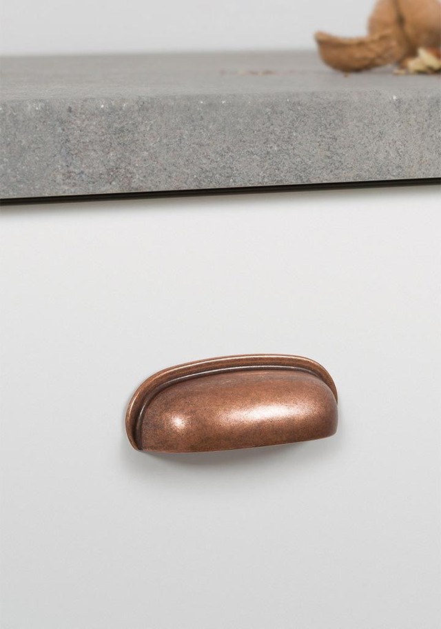 AURA Muschelgriff aus Zamak mit klassischem Vintage-Design an einer gerahmten Schubladenfront montiert.