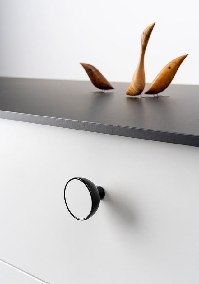 BOL runder Holz- und Aluminiumknopf mit schalenförmigem Design an einer modernen Möbeltür montiert.