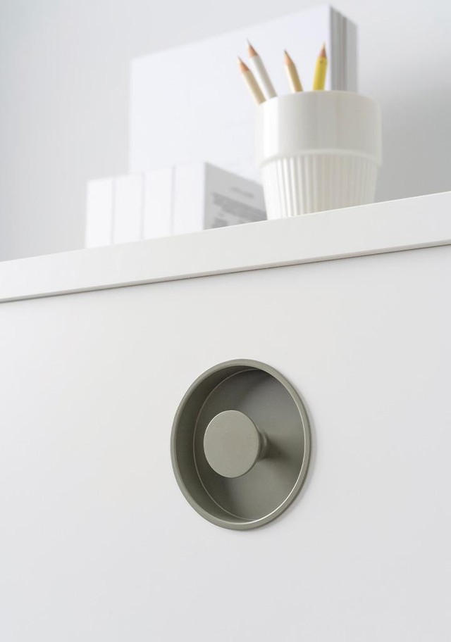 DIPO runder Einlassgriff aus Zamak mit minimalistischem Design in eine moderne Schrankfront integriert.