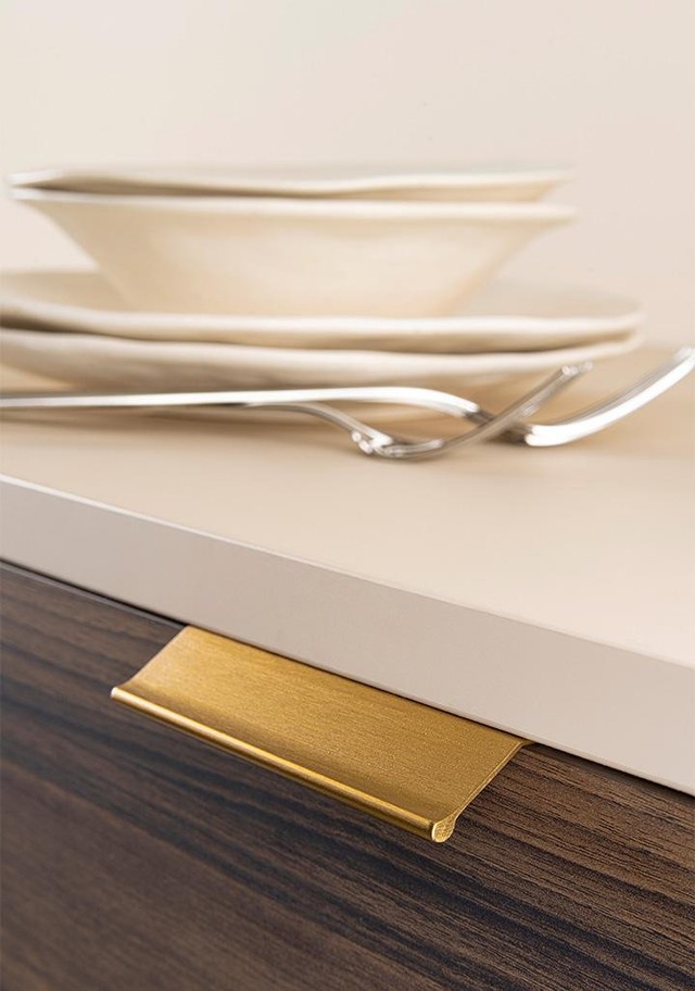 WING Aluminium-Profilgriff mit eleganter flügelförmiger Gestaltung an einer modernen Schranktür montiert.