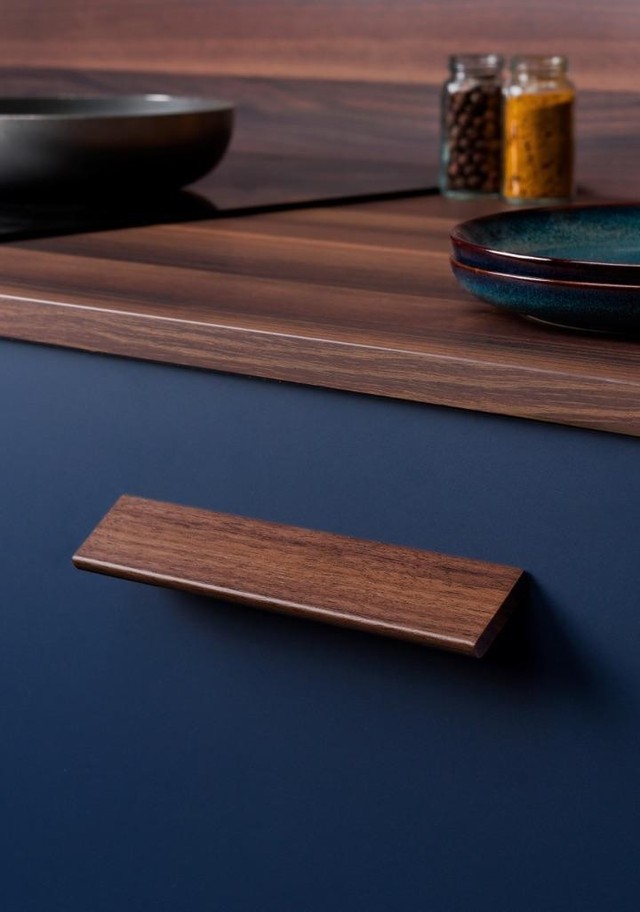CANO Massivholzgriff mit abgerundetem, minimalistischem Profil, horizontal an einer modernen Möbelschublade montiert.