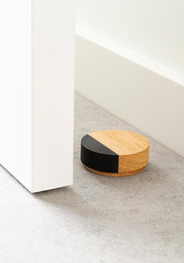 PUK wooden door stopper in Oak, Walnut or Matt Black Lacquered Ash with round minimalist design.